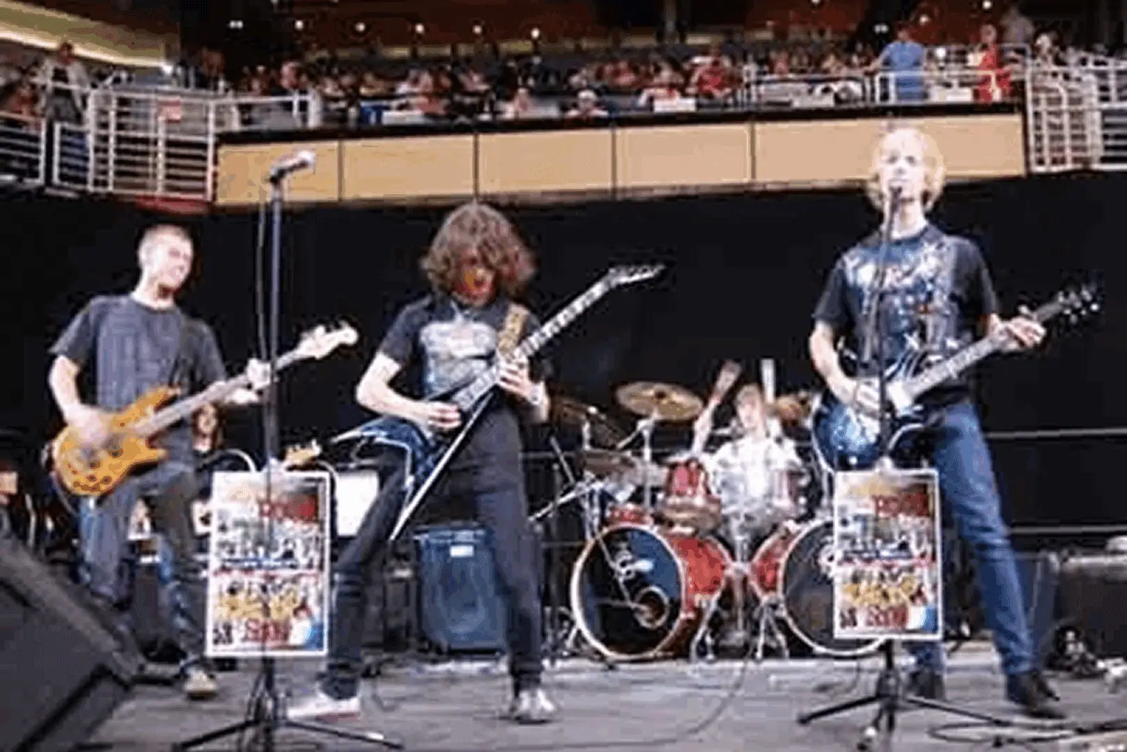 Rock band performing on stage with instruments.