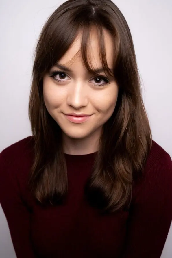 Young woman with long hair and warm smile.